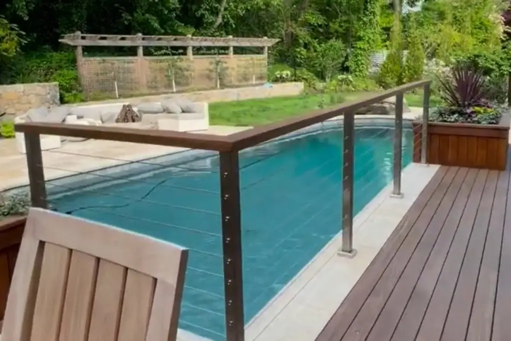 Glass and aluminum railing surrounding a poolside deck