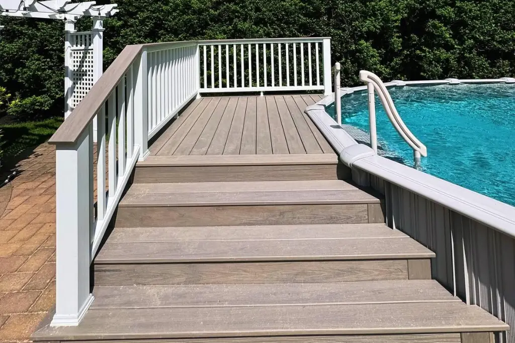 White composite railing surrounding a backyard pool, providing safety and a clean, modern aesthetic.